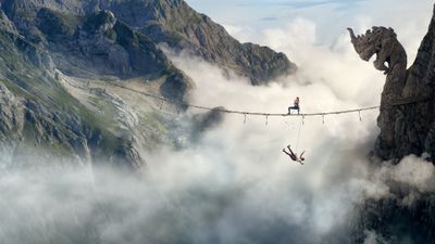 4K UHD Fall 2 Deadpoint mountain climbing wallpaper featuring a climber crossing a rope bridge above a misty mountain valley, high-resolution desktop background.