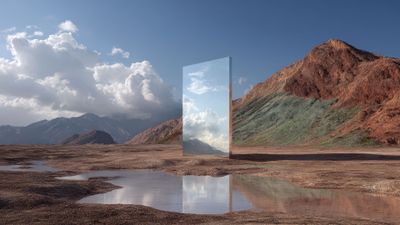 A large, vertical mirror stands in an arid mountainous landscape, reflecting a bright, cloud-filled sky, creating a surreal and serene contrast with the earthy surroundings.