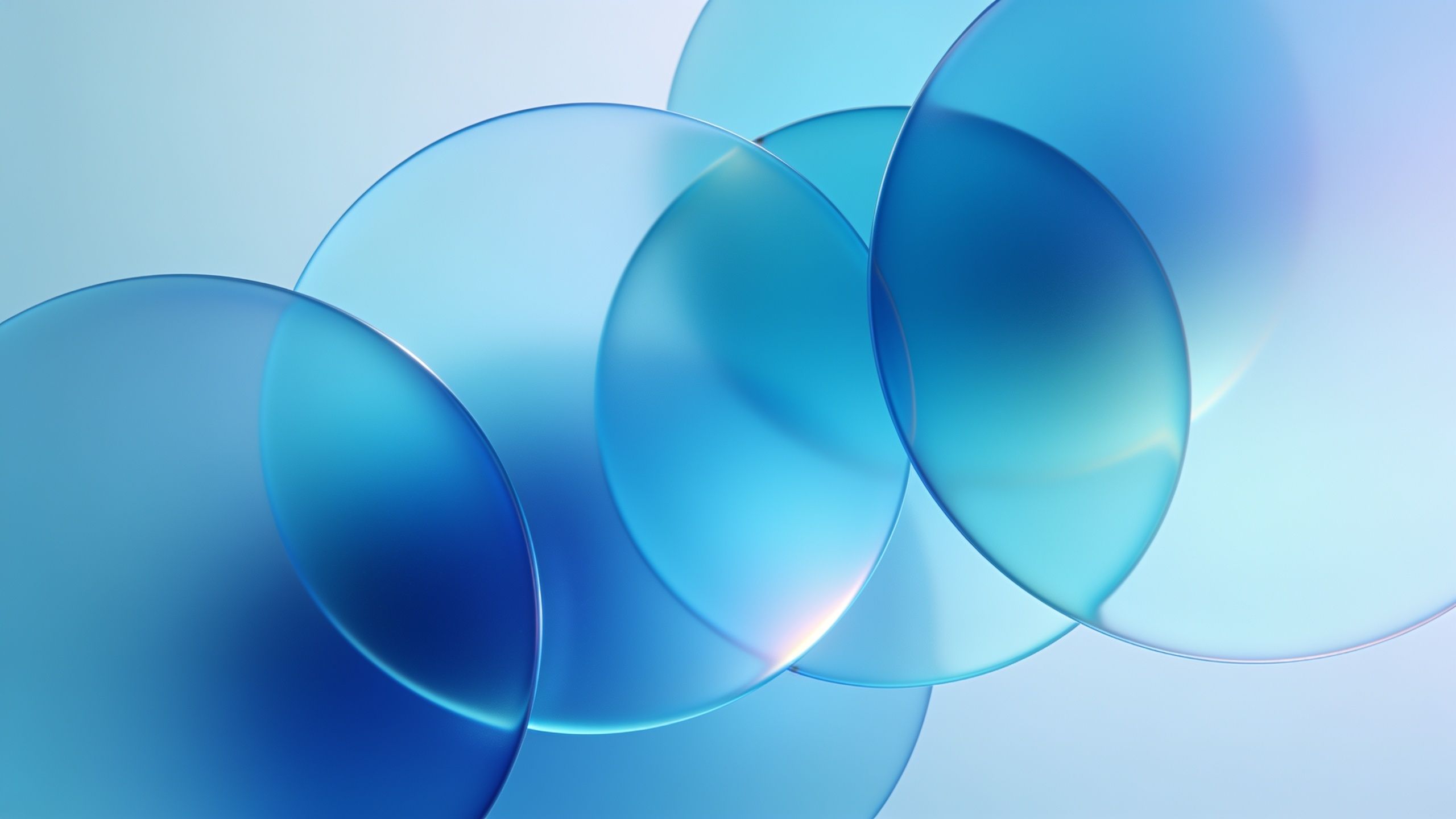 The wallpaper features overlapping translucent blue circles with soft gradients, creating a calming and serene abstract design against a light background. The smooth blending of colors evokes a tranquil and soothing mood.