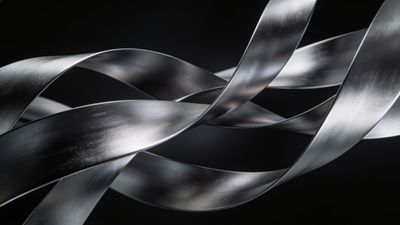 Abstract metallic ribbons twist and flow gracefully against a dark background, creating a sleek and modern aesthetic with a sense of fluid motion and elegance.