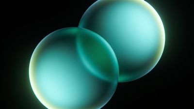 Two softly glowing turquoise spheres float against a dark background, creating a serene and futuristic ambiance.