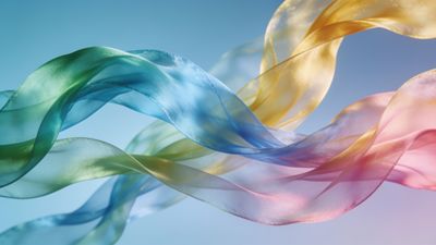 The image features vibrant silk ribbons in shades of green, blue, yellow, and pink, gracefully swirling against a soft blue background, creating a dynamic and lively atmosphere.
