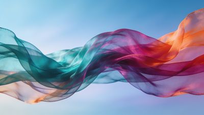 Colorful, translucent silk waves in shades of teal, pink, and orange float gracefully against a serene blue sky, creating a tranquil and uplifting mood.