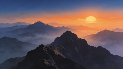 A breathtaking sunrise illuminates misty mountain peaks, casting a warm, golden glow over the rugged landscape and creating a serene, majestic atmosphere.