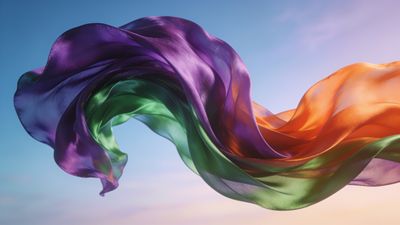 Vibrant silk fabric waves in shades of purple, green, and orange flow gracefully against a clear blue sky, creating a dynamic and uplifting atmosphere.