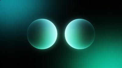Two luminous spheres emit a soft teal glow against a dark background, creating a serene and futuristic atmosphere.