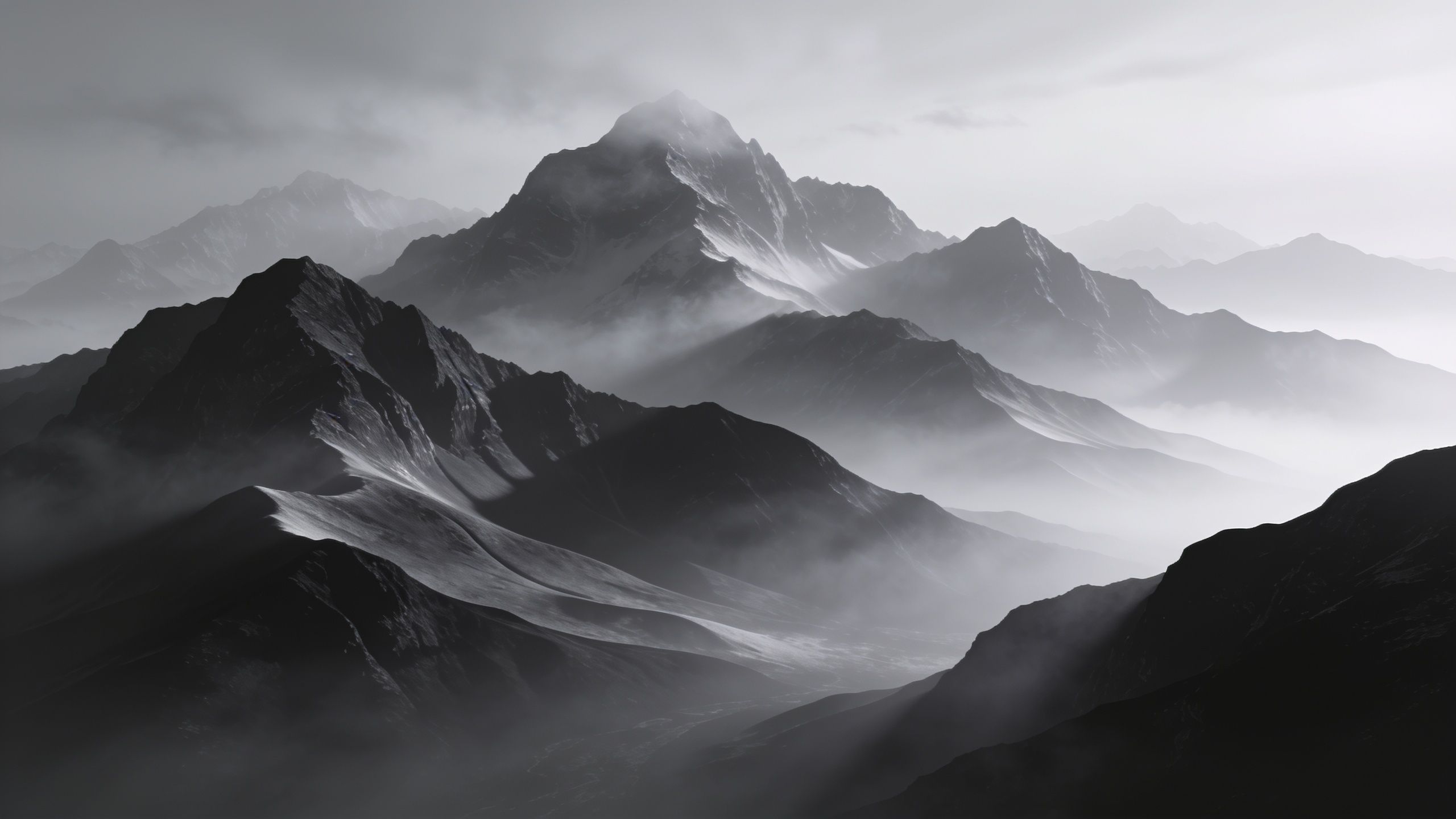 A dramatic black-and-white image of towering mountains shrouded in mist, creating a mysterious and serene atmosphere. The peaks are partially obscured by clouds, enhancing the sense of depth and majesty in the landscape.
