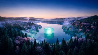 A translucent turquoise cube radiates softly from the center of a still mountain lake at dawn, its glow reflected in the glassy water. Mist curls above dense evergreens dotted with pink-violet blossoms, and the pastel sunrise sky heightens the scene’s serene, otherworldly mood.